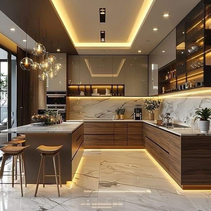 Dapur modern mewah dengan lantai marmer, kabinet kayu, lampu gantung bola, dan pencahayaan hangat.